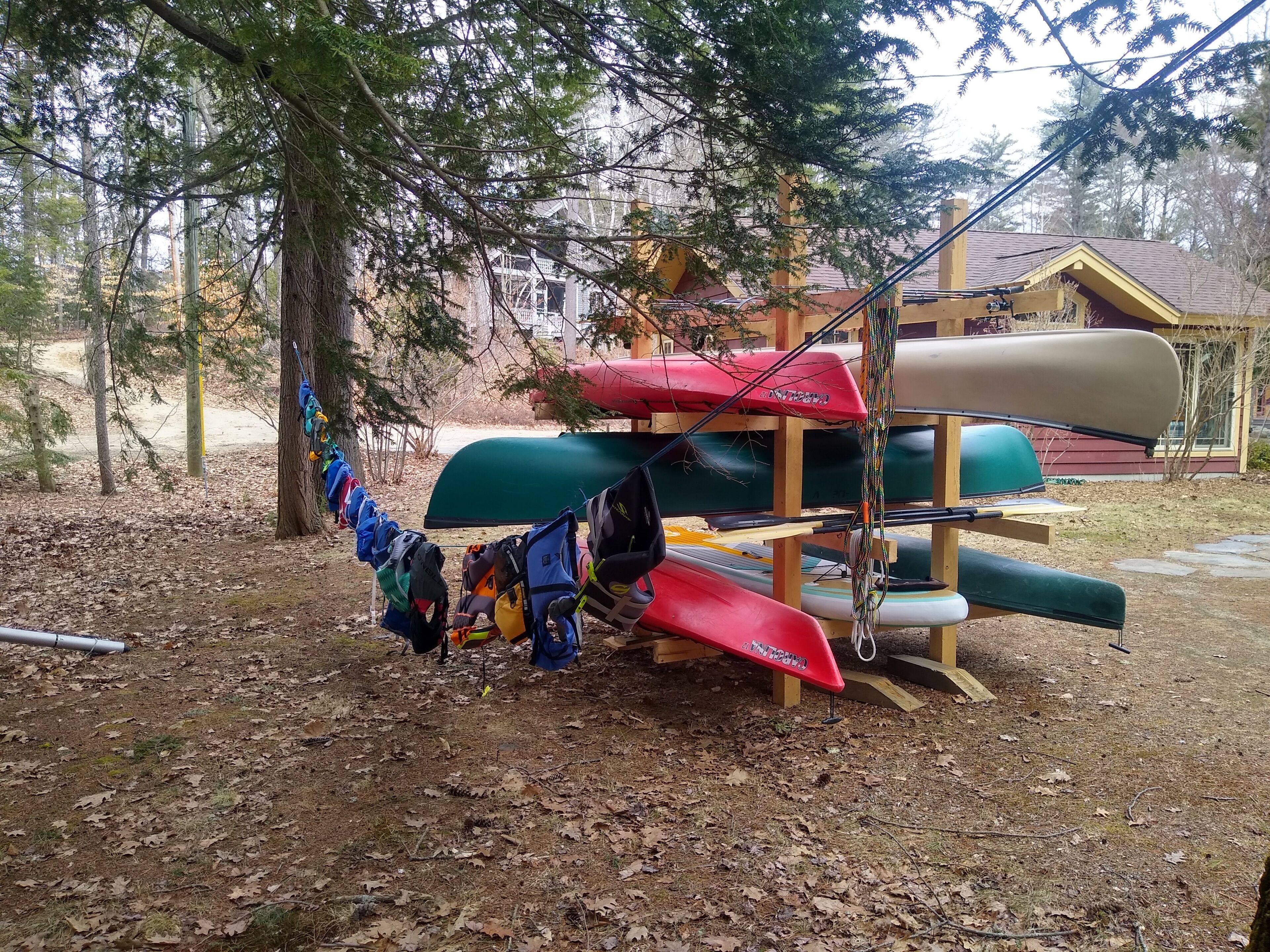Una estructura de madera con kayaks y una canoa.