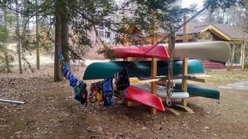 Una estructura de madera con kayaks y una canoa.