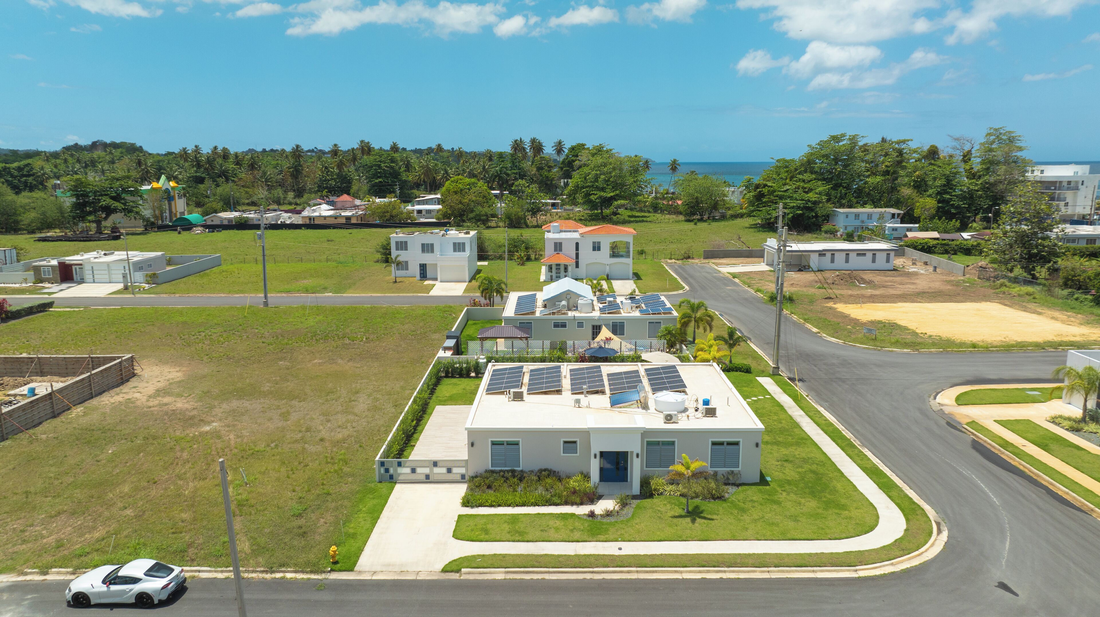 A residential area with houses, solar panels, and a road.