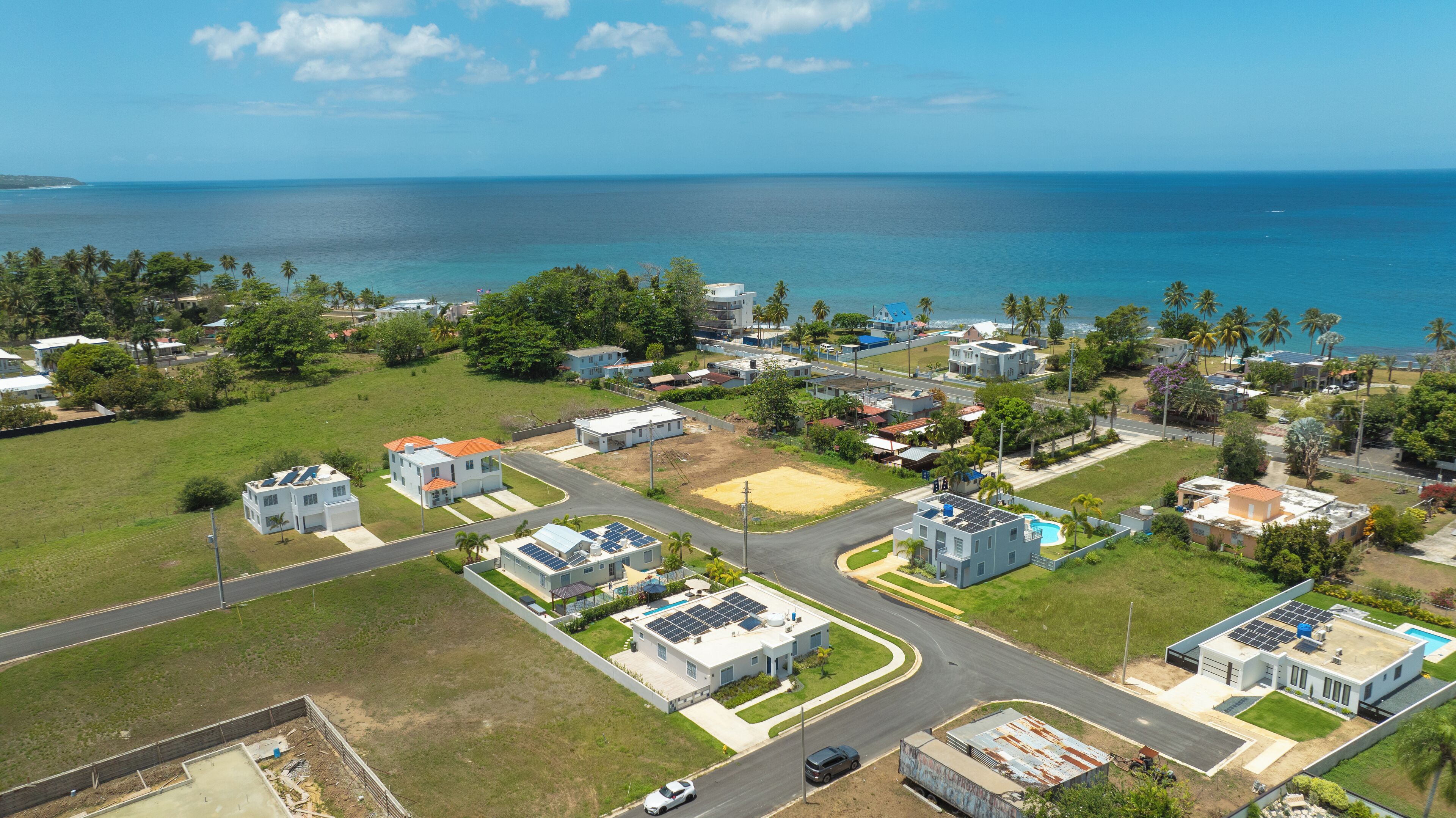 Vista aérea de una zona residencial costera con casas, calles y una playa.