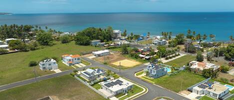 Vista aérea de una zona residencial costera con casas, calles y una playa.