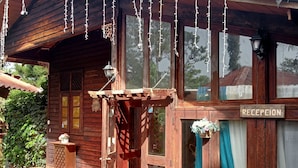 Un bâtiment en bois comprenant un espace d’accueil, de grandes fenêtres et une enseigne sur laquelle on peut lire « RÉCEPTION ».
