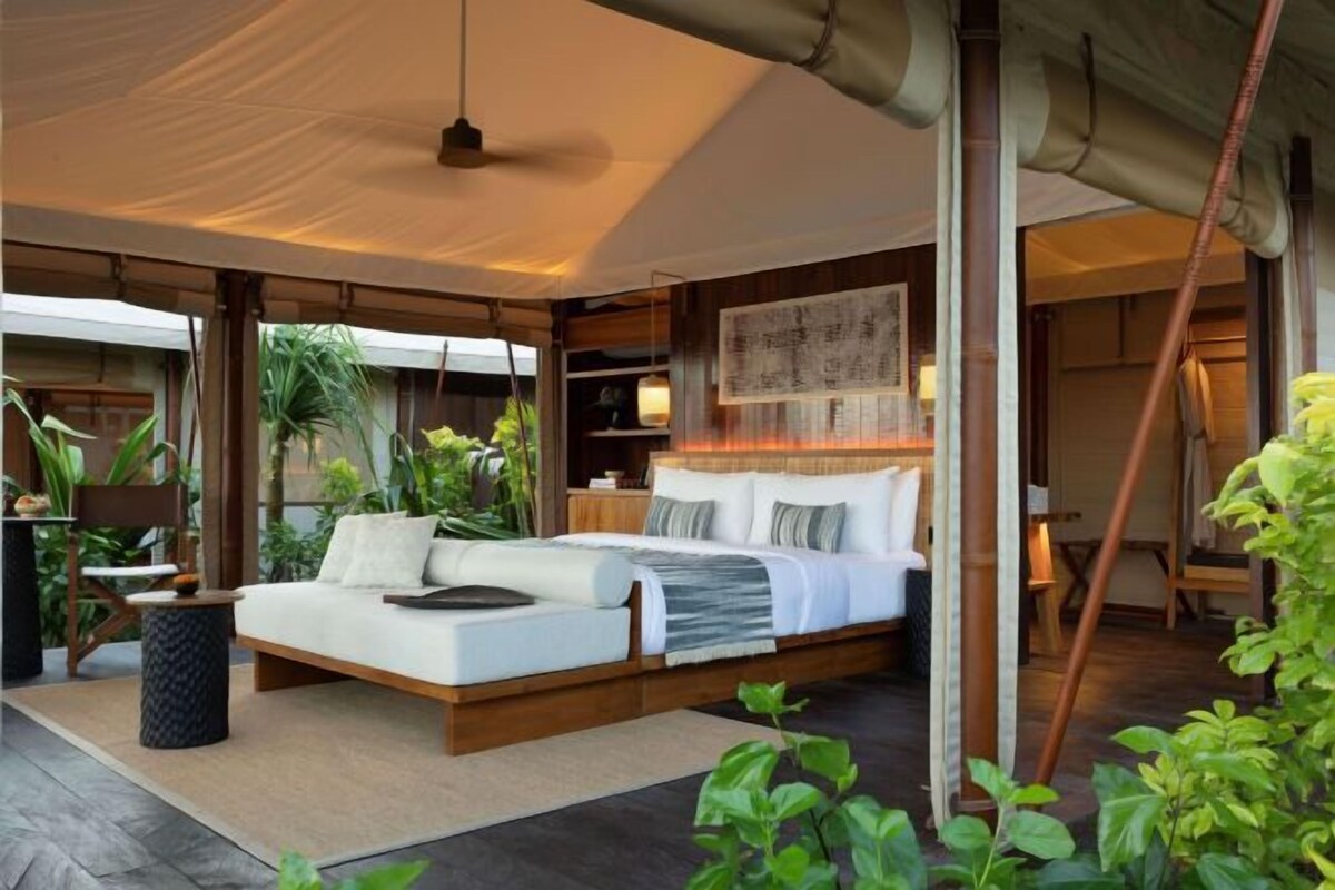 Une chambre spacieuse avec un grand lit, une table de chevet et une vue sur l’extérieur.