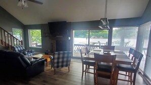 Àmplia zona de seients amb taula de menjador, cadires, sofà i ventilador de sostre.