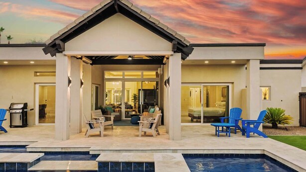 Una casa moderna con un porche cubierto, una piscina y un interior bien iluminado.