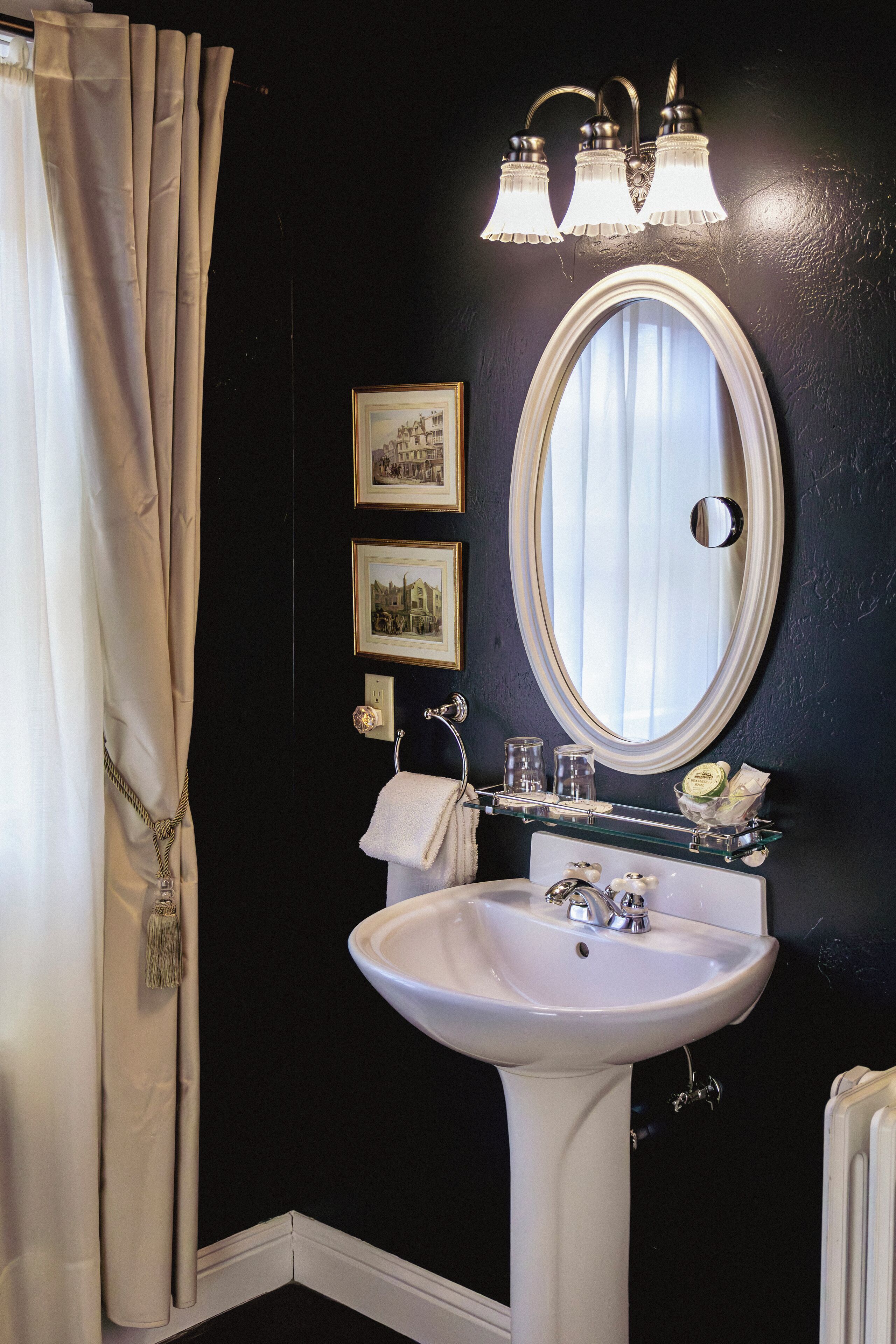 A bathroom with a white sink, a mirror, and three wall-mounted lights.