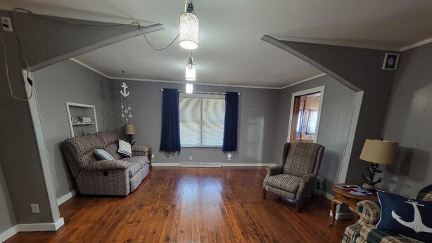 A spacious living room with hardwood flooring, a sofa, a chair, and a small table with a lamp. - Charming 3-bedroom house in tranquil Oraville minutes from  Kinkaid Lake.   (Oraville)