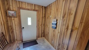 A wooden-paneled hallway with a bench, a door, and a welcome sign. - Charming 3-bedroom house in tranquil Oraville minutes from  Kinkaid Lake.   (Oraville)