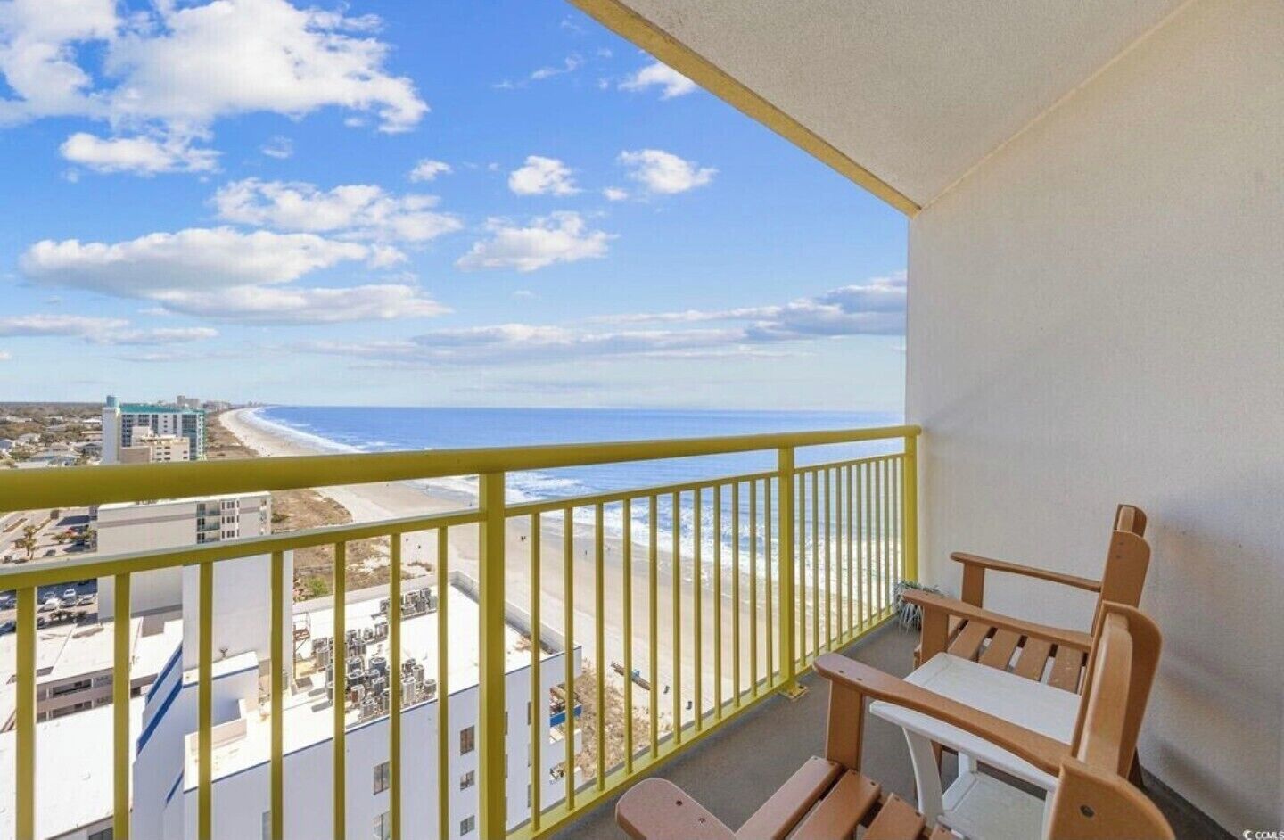 Ein Balkon mit Blick auf Strand und Meer.