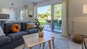 Una sala moderna con un sofá, una mesa de centro y vistas al patio exterior.