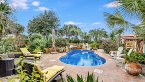 A swimming pool surrounded by outdoor furniture and lush greenery. - 3 bedroom cottage, peaceful and private, with pool, fitness, flowers and nature (Buda)
