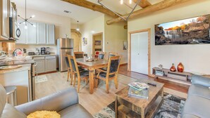 A modern kitchen with a dining area, wooden beams, and a waterfall painting. - 3 bedroom cottage, peaceful and private, with pool, fitness, flowers and nature (Buda)