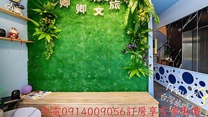 Une pièce avec un mur recouvert d’un gazon artificiel vert, des meubles en bois et des plantes décoratives.