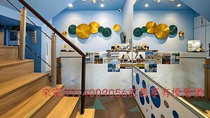 L’intérieur d’un hôtel avec un escalier, un comptoir d’accueil et des éléments décoratifs sur les murs.