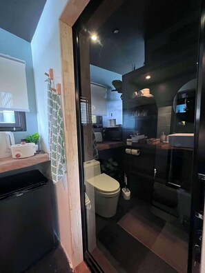 A compact kitchen with a refrigerator, stove, and sink.