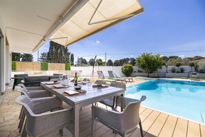 An outdoor pool area with a covered patio, lounge chairs, and a dining table set for six. - Brand new villa with exclusive  pool in Lecce. (Lecce)
