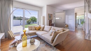 Amplia sala de estar con un sofá modular grande, una mesa de centro y vistas al exterior.