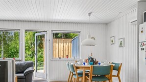 A modern kitchen with a dining area, white wooden walls, and a large window. - "Mani" - 1.1km from the sea by Interhome (Ebeltoft)