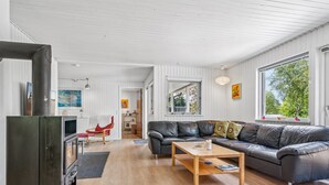 A modern living room with a fireplace, a leather sofa, and a wooden coffee table. - "Mani" - 1.1km from the sea by Interhome (Ebeltoft)