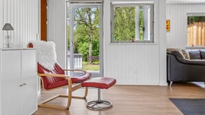 A modern living room with a red leather chair, a grey sofa, and a white cabinet. - "Mani" - 1.1km from the sea by Interhome (Ebeltoft)