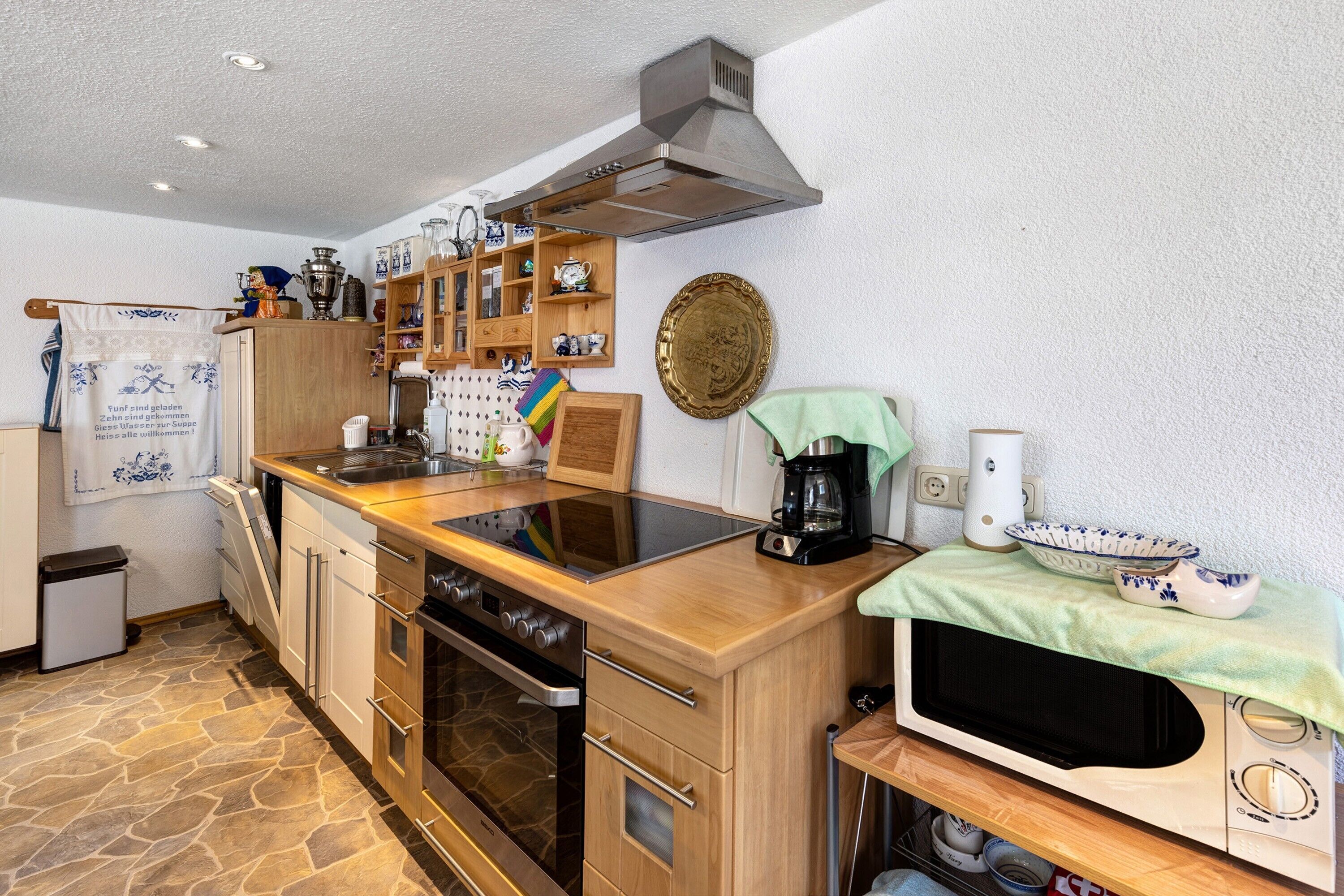 Eine kleine Küche mit Herd, Backofen, Mikrowelle und Kaffeemaschine.