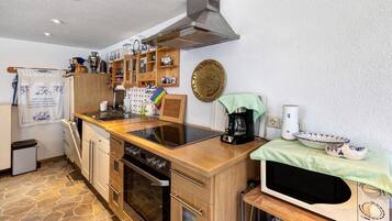 Eine kleine Küche mit Herd, Backofen, Mikrowelle und Kaffeemaschine.