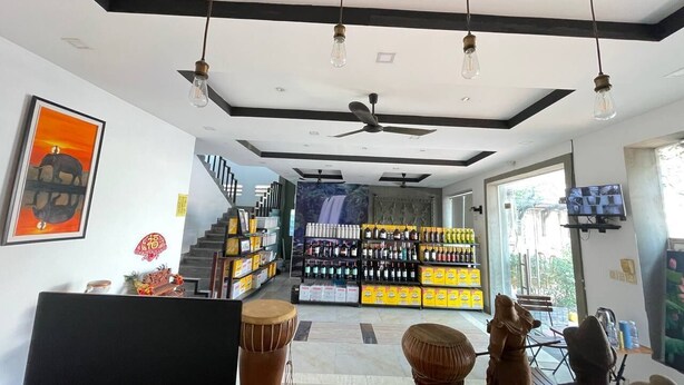 A modern living room with a flat-screen TV, a ceiling fan, and a staircase leading to a balcony. - Hotel 30 (Phnom Penh)