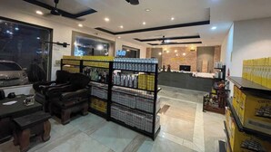 A modern interior with a seating area, a display of bottled beverages, and a reception desk. - Hotel 30 (Phnom Penh)