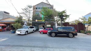 A hotel with a sign reading "Hotel 30" and several parked cars in front. - Hotel 30 (Phnom Penh)