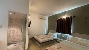 A modern hotel room with a glass shower enclosure, a bed with a headboard, and a bedside table. - Hotel 30 (Phnom Penh)