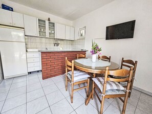 Een koelkast, een oven, kookgerei, borden en bestek