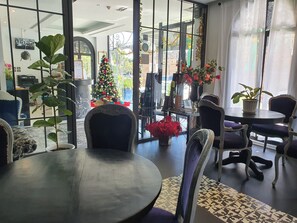 Ein modernes Interieur mit einem runden Tisch, Stühlen, einem Weihnachtsbaum und Topfpflanzen.