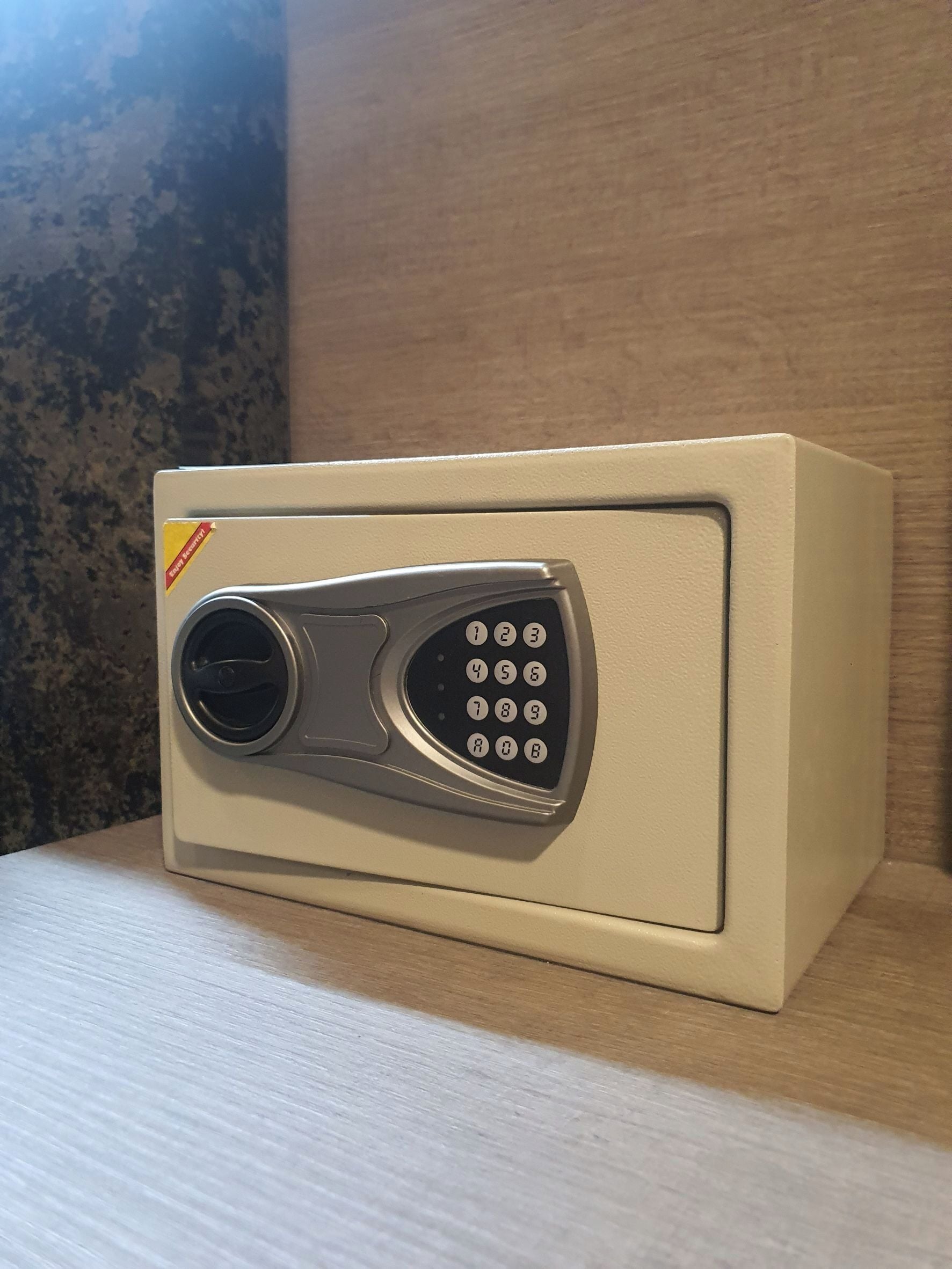 A keypad entry device on a beige wall, likely for a secure room or safe.