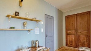 A room with a wooden table, a door, and a cabinet. - Maison Oléa - "Élégance" guest room overlooking the Vézère valley. (Le Bugue)