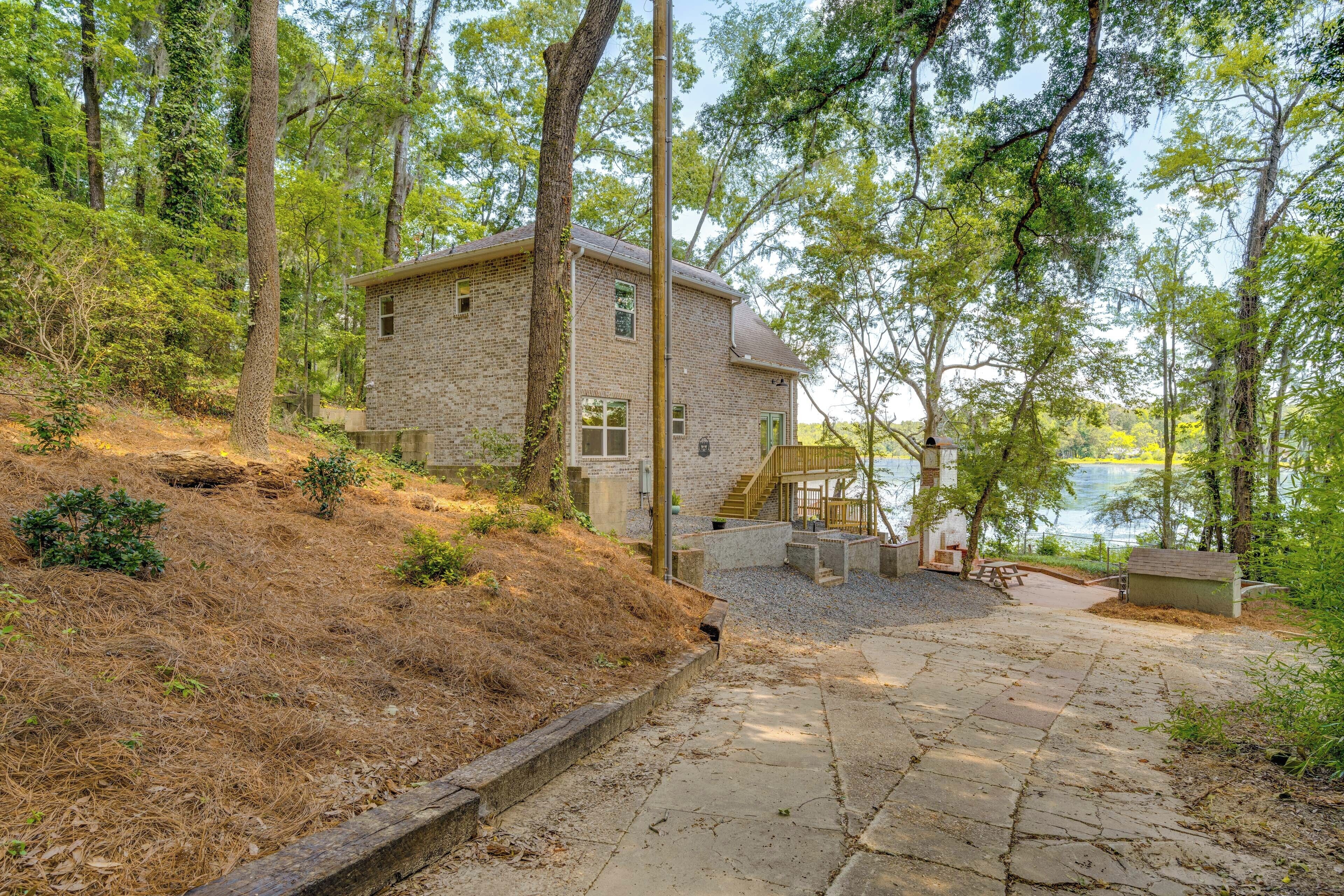 Una casa de pedra amb una terrassa de fusta i vista a un llac.