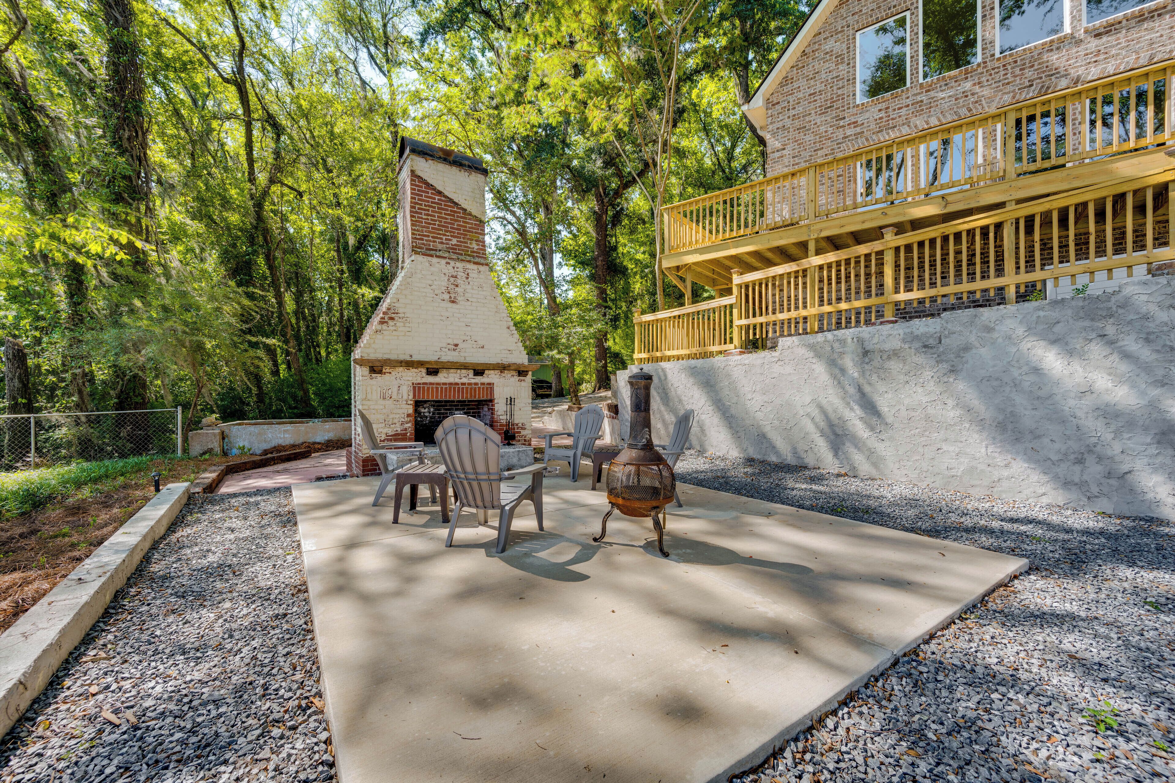 A patio with a brick fireplace, outdoor furniture, and a wooden deck.