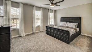 A bedroom with a bed, a ceiling fan, and a dresser. - Fenced Yard & Patio! 2,400-Sq-Ft Chesapeake Home (Chesapeake)