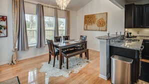 A modern kitchen with a dining area, granite countertops, and a chandelier. - Fenced Yard & Patio! 2,400-Sq-Ft Chesapeake Home (Chesapeake)