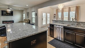 A modern kitchen with granite countertops, stainless steel appliances, and a large island. - Fenced Yard & Patio! 2,400-Sq-Ft Chesapeake Home (Chesapeake)