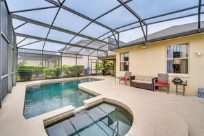 An indoor swimming pool with a glass ceiling, surrounded by lounge chairs and a small table. - 14 Mi to Disney: Spacious Home w/ Pool & Lanai! (Davenport)
