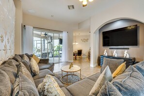 Relax in this stylish living area with a comfortable sofa, flat-screen TV, and balcony access.