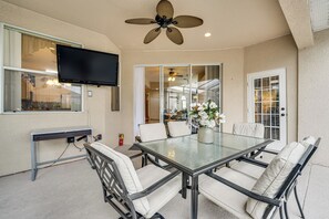 Relax in this cozy patio area with a dining table, comfortable chairs, and a flat-screen TV for entertainment.