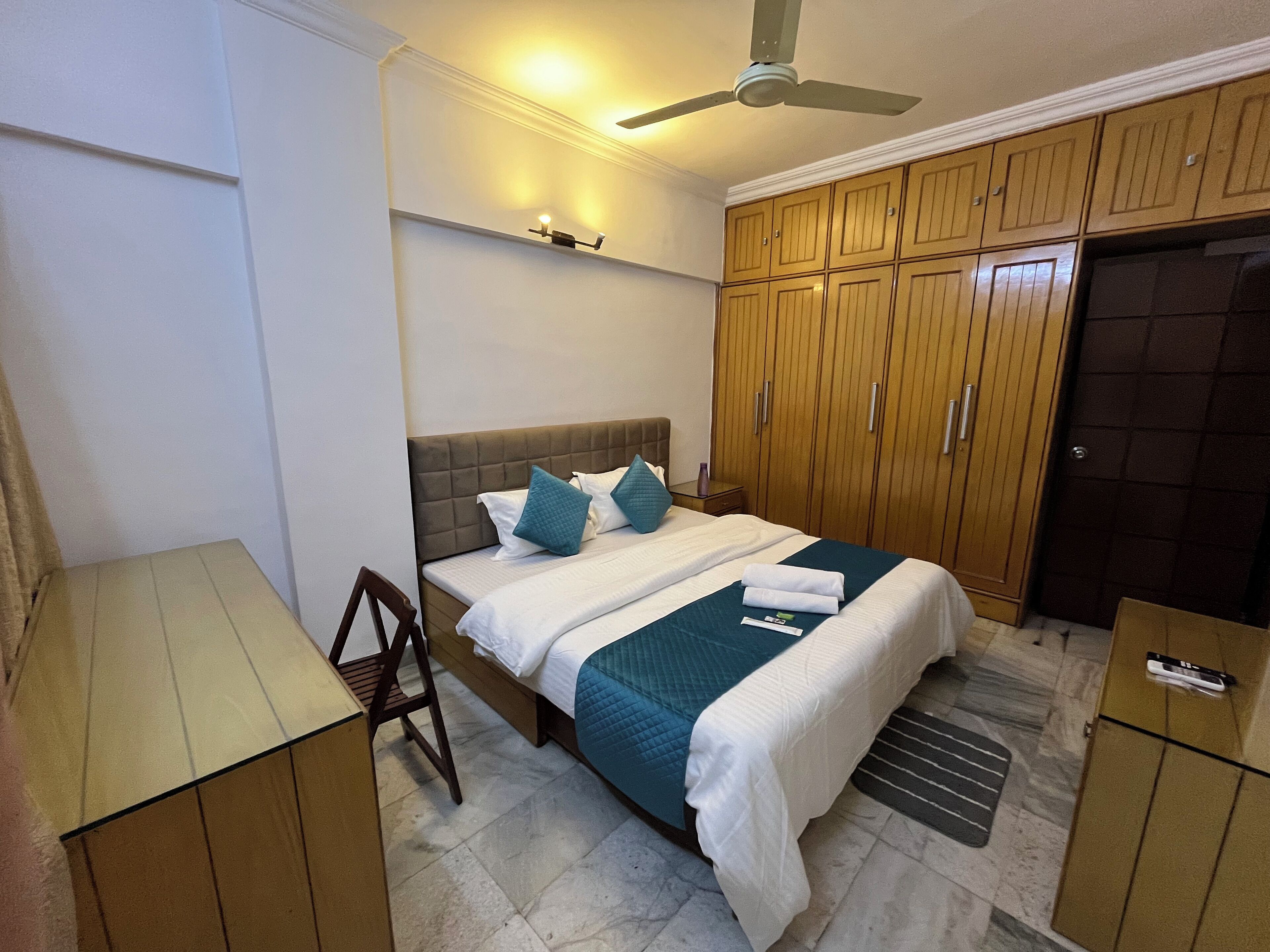 Un dormitorio con cama, armario de madera y escritorio.