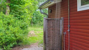 A wooden house with a metal shower enclosure and a brick pathway leading to it. - "Lovisa" - 7km from the sea by Interhome (Rønde)
