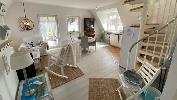 A modern interior with a staircase, a dining area, and a kitchen. - Apartment 'Ferienwohnung Parkblick 2' with Private Terrace, Balcony and Wi-Fi (Lübeck Travemünde)