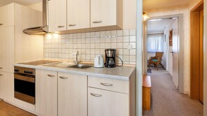 A kitchen with a stove, oven, sink, and coffee maker. - Apartment 'Wohnung 1 Birke' with Wi-Fi (Willingen (Upland))