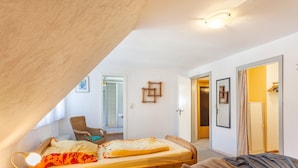 A bedroom with a bed, a chair, a bedside table, a lamp, and a wardrobe. - Apartment 'Wohnung 1 Birke' with Wi-Fi (Willingen (Upland))