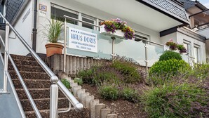 A building with a sign indicating 'HAUS DORIS' and a staircase leading to the entrance. - Apartment 'Ferienhaus Doris' with Mountain View, Private Terrace and Wi-Fi (Willingen (Upland))