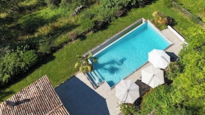 An aerial view of a rectangular swimming pool surrounded by a wooden deck and lush greenery. - Maison Oléa - Chambre D'hôtes "naturéa" Avec vue sur la Vallée de la Vézère (Le Bugue)