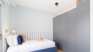 A bedroom with a bed, bedside lamps, and a wardrobe. - LUX 3BR House Pool Gym 7-Min Walk Palm Beach - Porta Al Sole 7 by Bocobay (Noord)